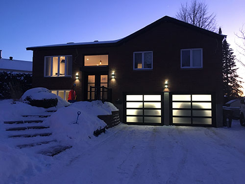 Maison spacieuse avec une allée menant au garage, située dans un environnement résidentiel.