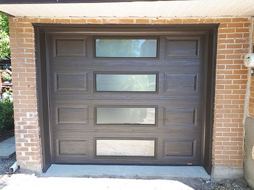 Porte de garage avec une finition marron, affichant une surface lisse et un design classique.