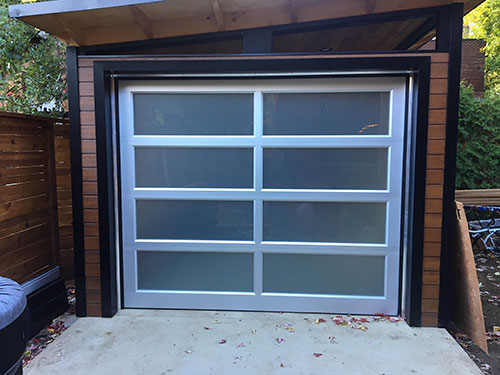 Une porte de garage avec de grandes fenêtres, offrant un accès pratique et moderne.