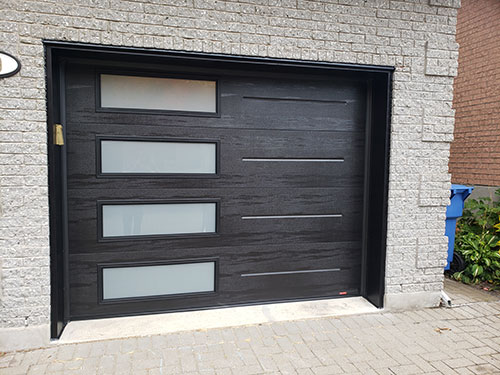 Porte de garage noire avec panneaux en verre, offrant un design moderne et élégant.