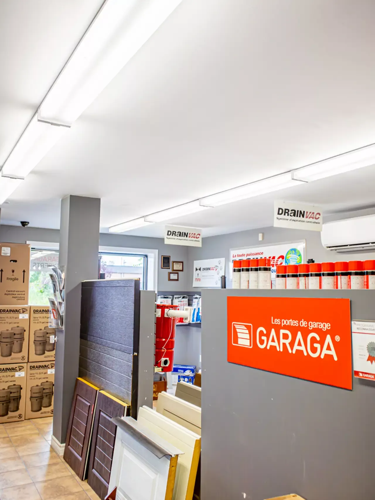 Intérieur de la salle de montre de Distribution BD avec panneaux de porte de garage et affiche Garaga