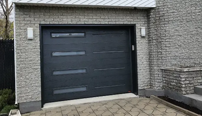 Garage moderne avec une porte noire dotée d'une fenêtre horizontale