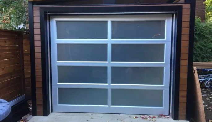 Une porte de garage avec de grandes fenêtres, offrant un accès pratique et moderne.