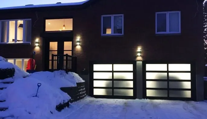 Maison spacieuse avec une allée menant au garage, située dans un environnement résidentiel.